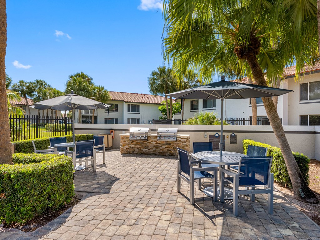 A patio with a table and chairs under an umbrella.